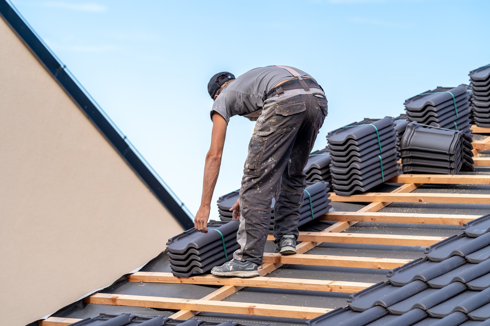 new roof of a family house, a roofer builds a roof made of ceramic tiles