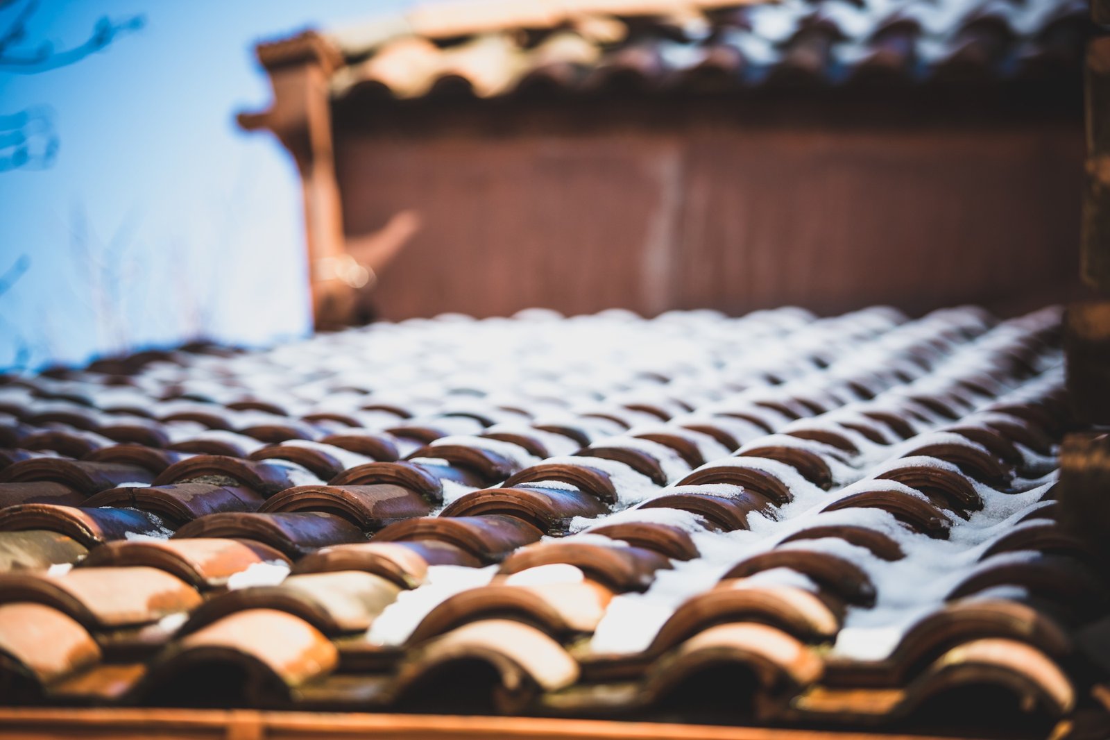 snow on red tiled roof
